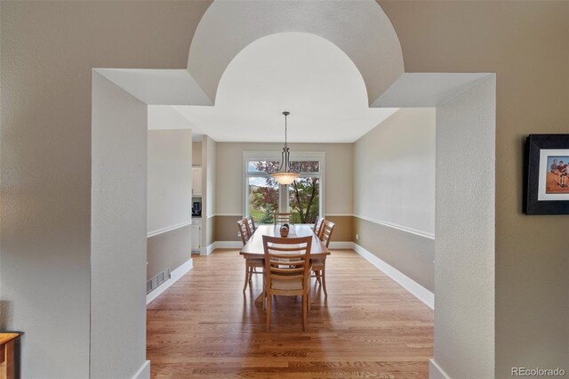 dining room with baseboards, light wood-style flooring, and visible vents