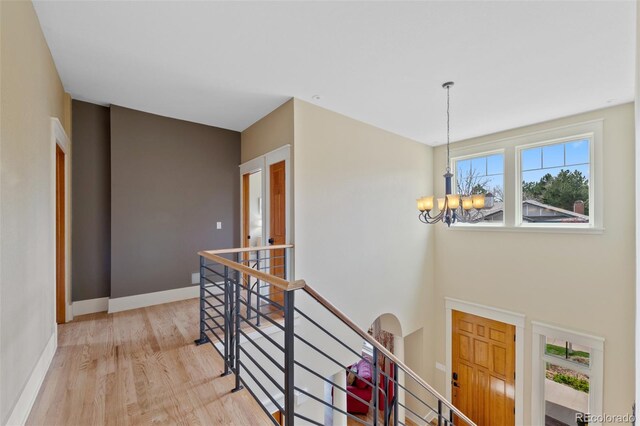 interior space with baseboards, an inviting chandelier, and light wood-style flooring