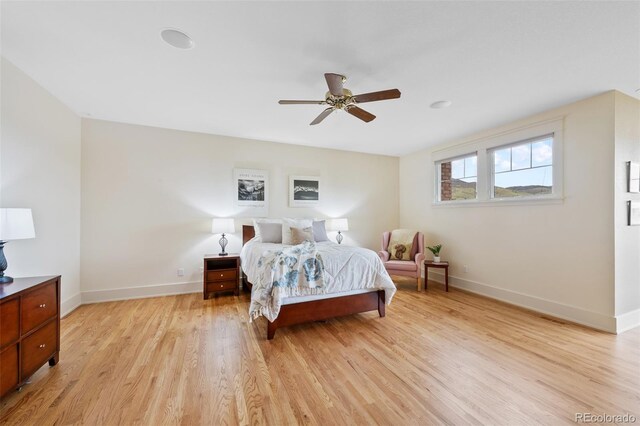 bedroom with a ceiling fan, baseboards, and light wood finished floors