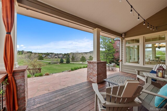 wooden terrace with a yard and a patio