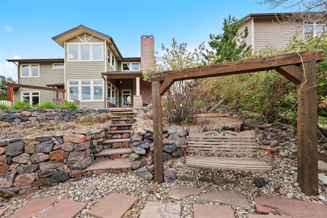 back of property with a chimney