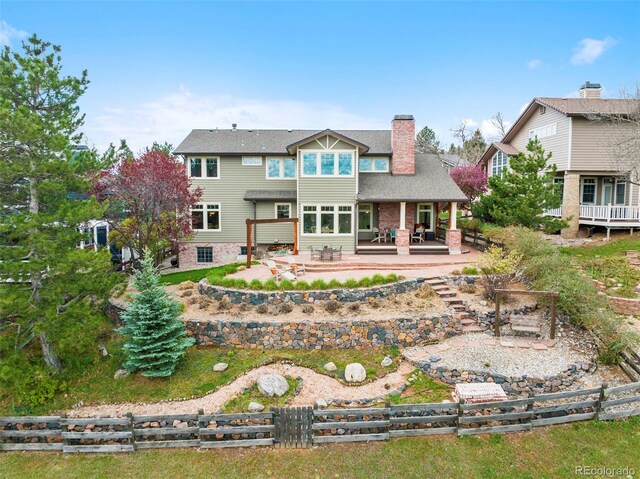 back of house featuring a patio, fence, and a chimney