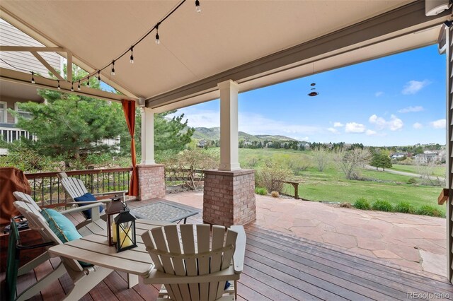 deck with a lawn and a mountain view
