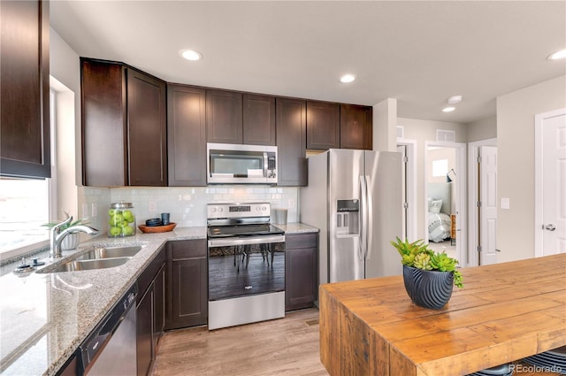 46534 Avery Ln, Bennett, CO 80102 - kitchen featuring stainless steel appliances, a sink, dark brown cabinets, light wood finished floors, and recessed lighting
