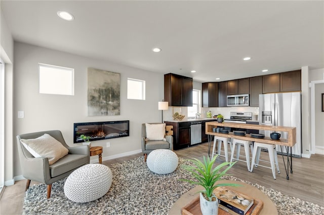 46534 Avery Ln, Bennett, CO 80102 - living room featuring baseboards, recessed lighting, and light wood finished floors