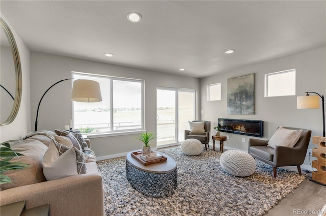 46534 Avery Ln, Bennett, CO 80102 - living room featuring baseboards, wood finished floors, a glass covered fireplace, and recessed lighting