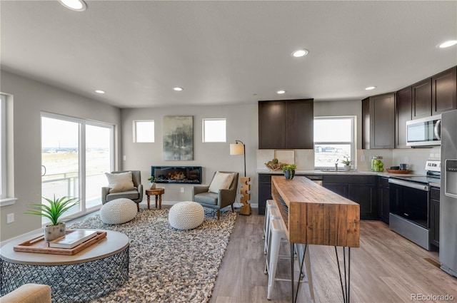 46534 Avery Ln, Bennett, CO 80102 - kitchen with appliances with stainless steel finishes, a sink, butcher block countertops, healthy amount of natural light, and recessed lighting
