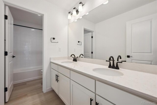 24768 E 40th Ave, Aurora, CO 80019 - bathroom featuring wood finished floors, toilet, double vanity, and shower / bath combination