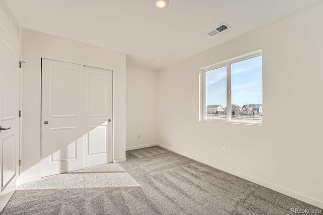 unfurnished bedroom featuring a closet and light carpet