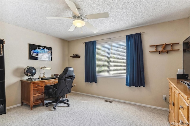 carpeted office space featuring a textured ceiling, ceiling fan, and baseboards