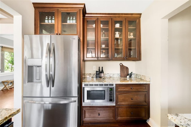 315 S Franklin St, Denver, CO 80209 - kitchen with stainless steel appliances, glass insert cabinets, dark wood finished floors, light stone counters, and baseboards