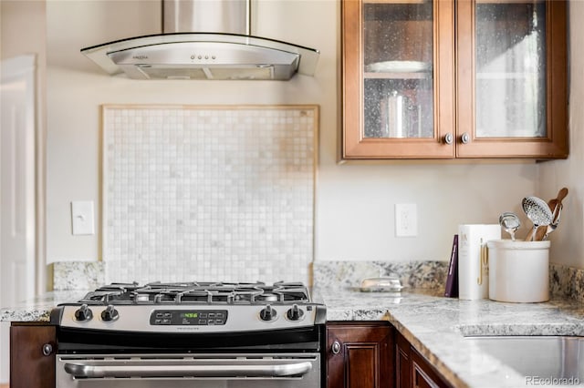 315 S Franklin St, Denver, CO 80209 - kitchen with stainless steel gas stove, under cabinet range hood, glass insert cabinets, and tasteful backsplash