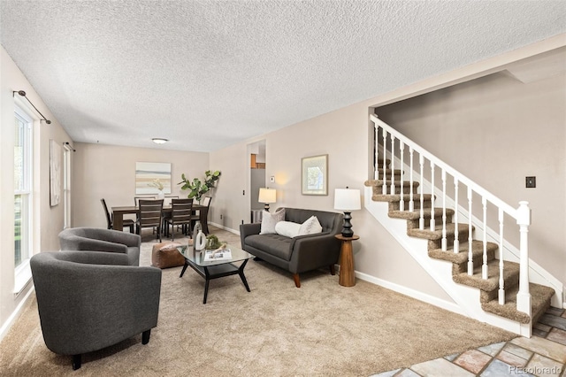 carpeted living area with stairway, a textured ceiling, and baseboards