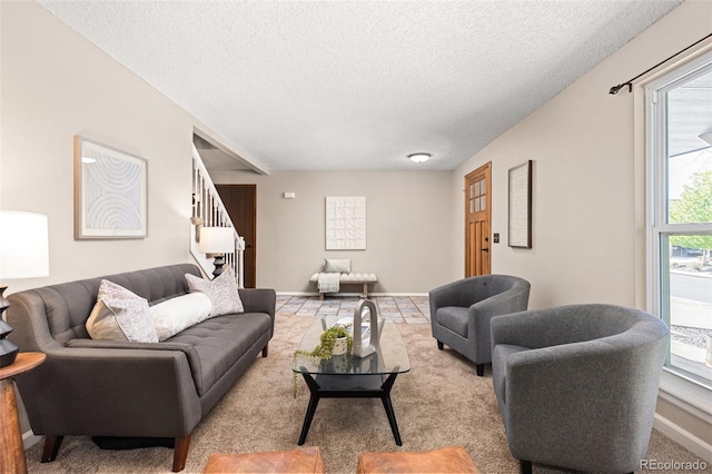 living area with stairs, a textured ceiling, and baseboards
