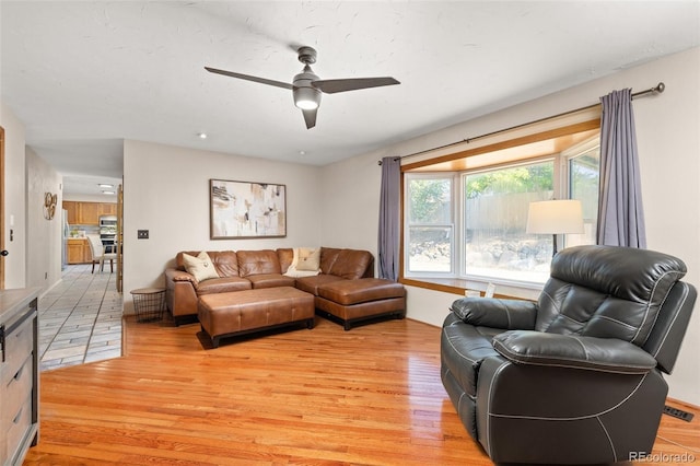 living room featuring light wood-style floors and ceiling fan