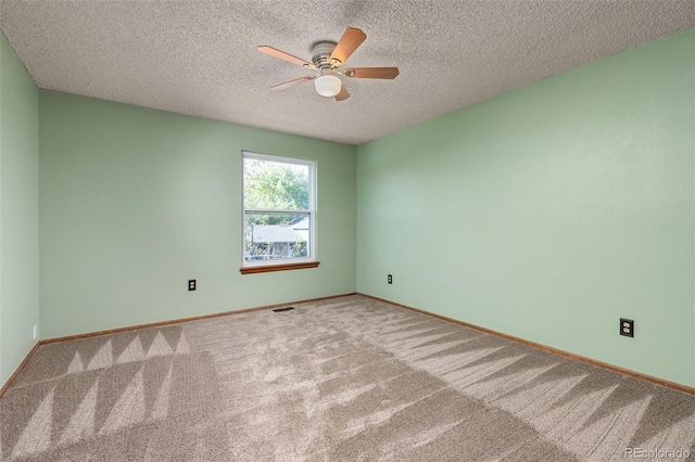 carpeted empty room with ceiling fan, baseboards, and a textured ceiling