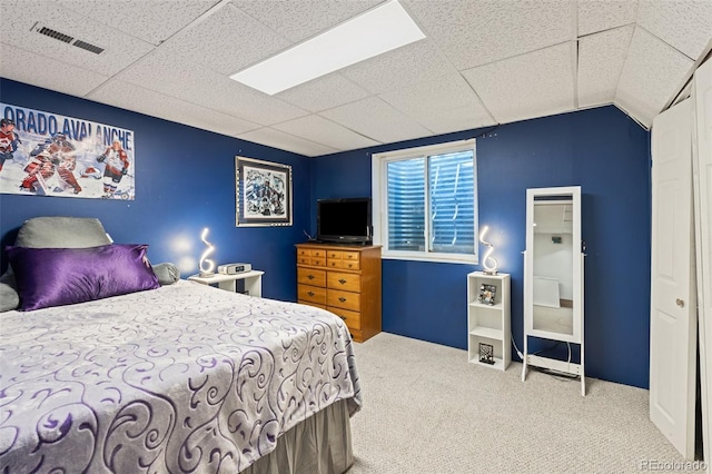 carpeted bedroom with a paneled ceiling