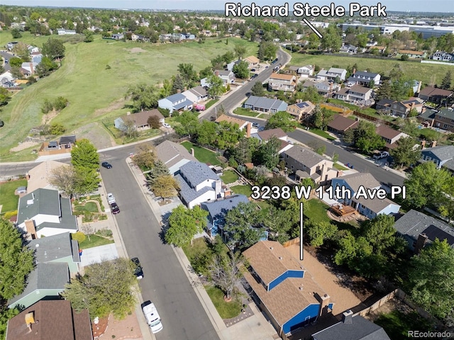 aerial view of property and surrounding area with nearby suburban area and a golf course