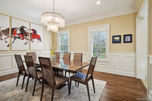 dining space with ornamental molding, a notable chandelier, and dark hardwood / wood-style floors