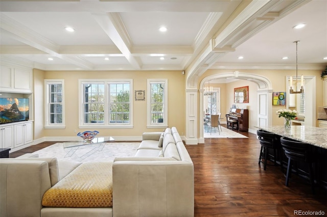 living room featuring dark hardwood / wood-style flooring, an inviting chandelier, coffered ceiling, ornamental molding, and beam ceiling