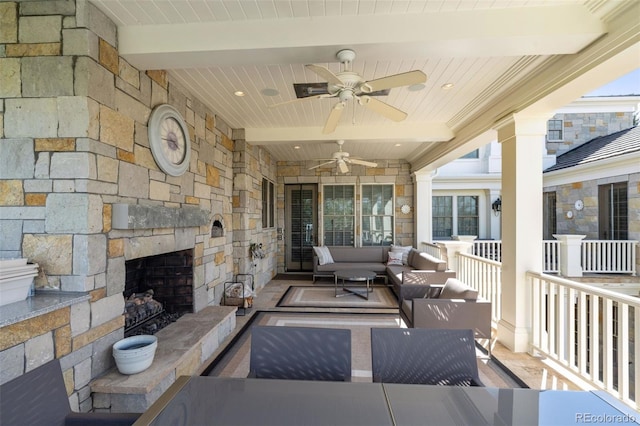 view of patio / terrace featuring ceiling fan and an outdoor living space with a fireplace