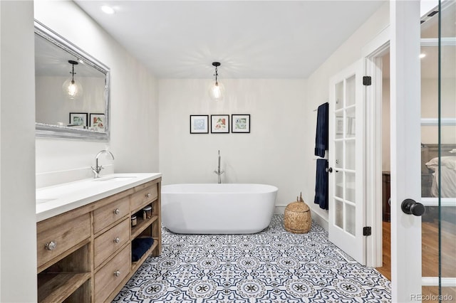 bathroom with vanity, a tub, and french doors