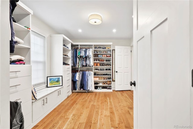 walk in closet with light hardwood / wood-style floors