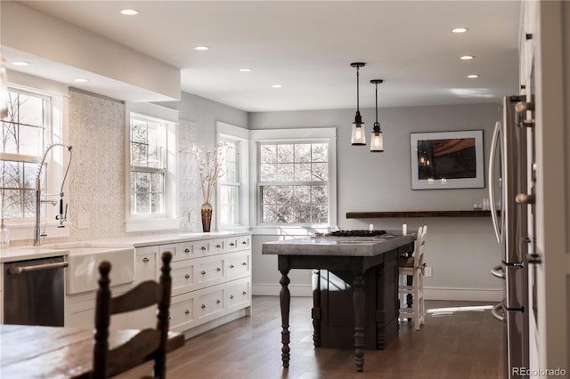 dining room featuring dark hardwood / wood-style flooring, sink, and plenty of natural light