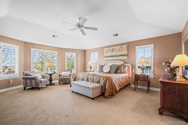 carpeted bedroom with ceiling fan, a tray ceiling, and vaulted ceiling