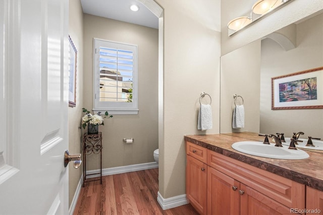 bathroom with vanity, hardwood / wood-style floors, and toilet