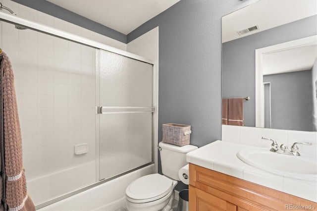 full bathroom with vanity, toilet, and combined bath / shower with glass door