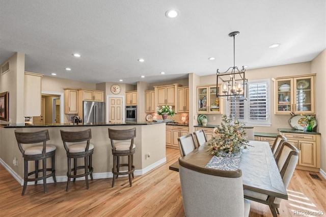 dining room with light wood finished floors, recessed lighting, visible vents, and an inviting chandelier