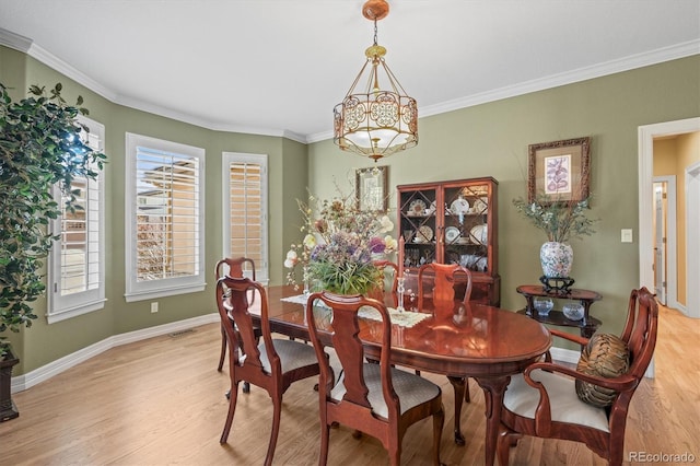 dining area with visible vents, baseboards, light wood-style flooring, crown molding, and a chandelier