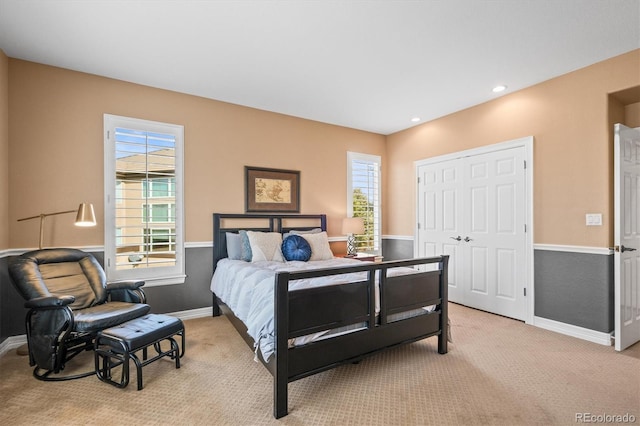 bedroom with recessed lighting, a closet, light colored carpet, and baseboards