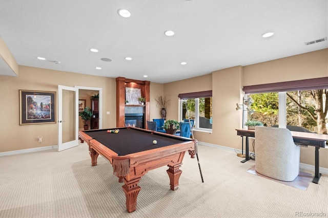 game room featuring recessed lighting, visible vents, a glass covered fireplace, and light colored carpet