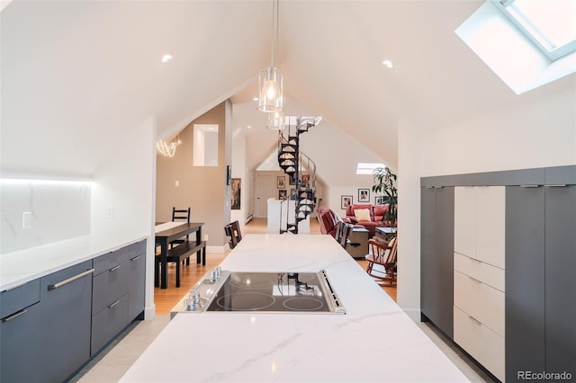 1165 N Pennsylvania St Unit 3B, Denver, CO 80203 - kitchen featuring a skylight, electric stovetop, vaulted ceiling, pendant lighting, and modern cabinets