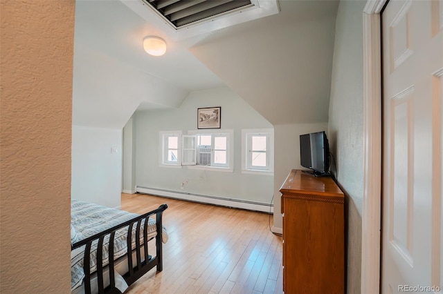 1165 N Pennsylvania St Unit 3B, Denver, CO 80203 - unfurnished bedroom with a baseboard heating unit, light wood finished floors, and vaulted ceiling
