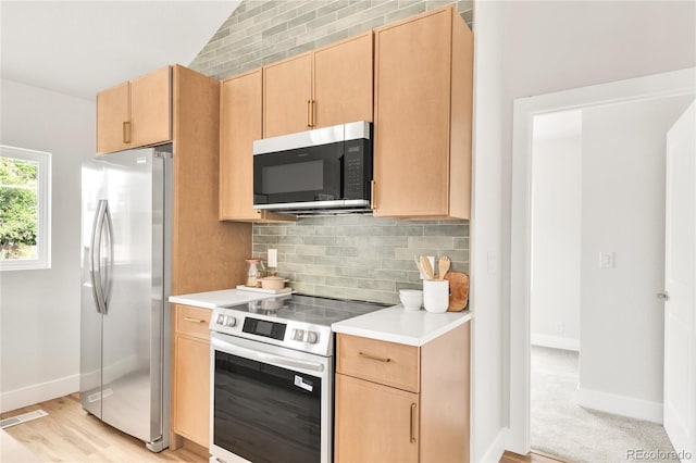 2600 S Downing St, Denver, CO 80210 - kitchen featuring stainless steel appliances, light brown cabinetry, light countertops, backsplash, and vaulted ceiling