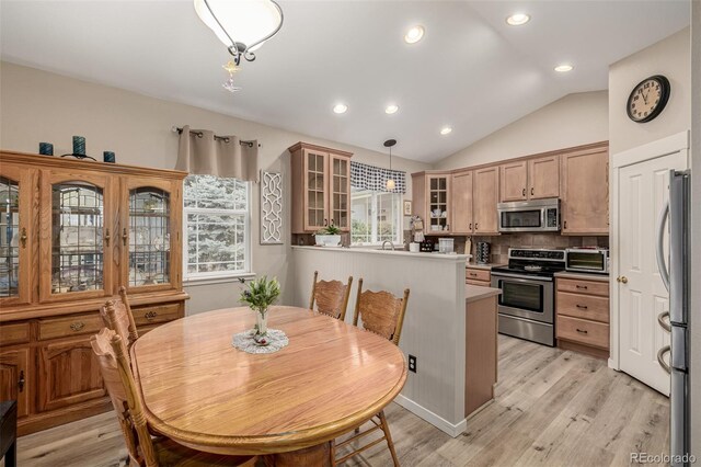13263 Niwot Trl, Broomfield, CO 80020 - kitchen featuring stainless steel appliances, glass insert cabinets, backsplash, light wood finished floors, and vaulted ceiling