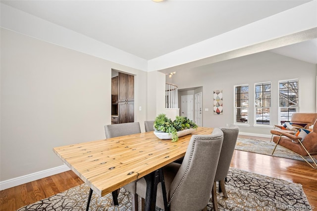 dining space featuring hardwood / wood-style floors and lofted ceiling