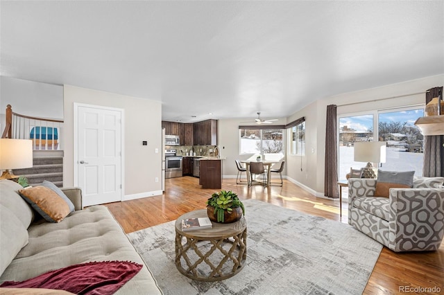 living room with ceiling fan and light hardwood / wood-style flooring