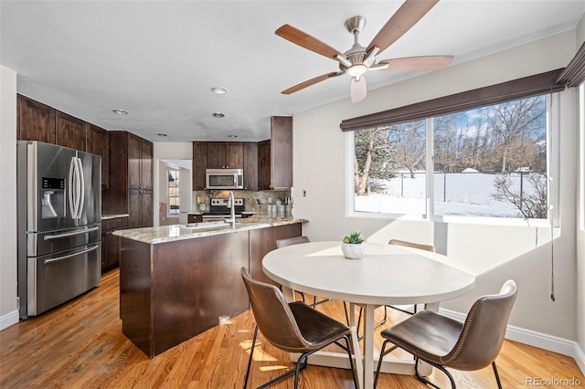 dining room with ceiling fan and light hardwood / wood-style flooring