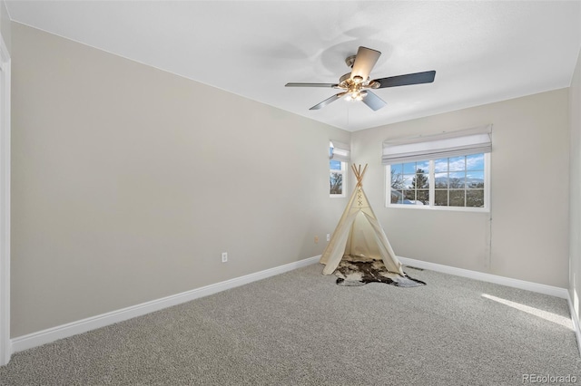 recreation room with ceiling fan and carpet