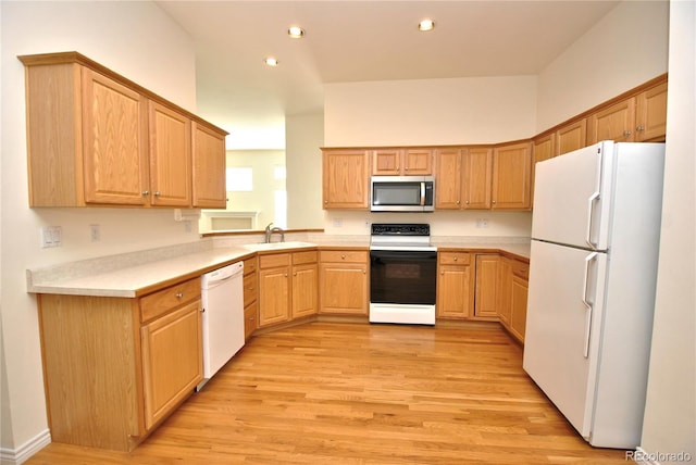 kitchen featuring white appliances, light wood-style flooring, light countertops, a sink, and recessed lighting