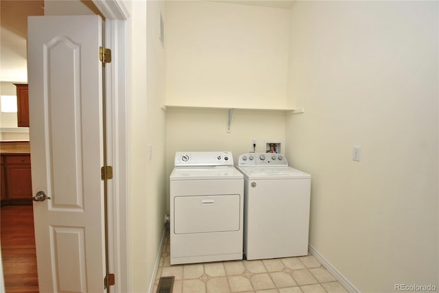 washroom with laundry area, independent washer and dryer, visible vents, and baseboards