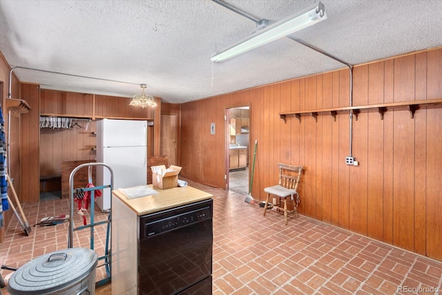 kitchen featuring dishwasher, white fridge, a chandelier, and wooden walls