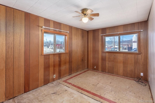 empty room with plenty of natural light and wood walls