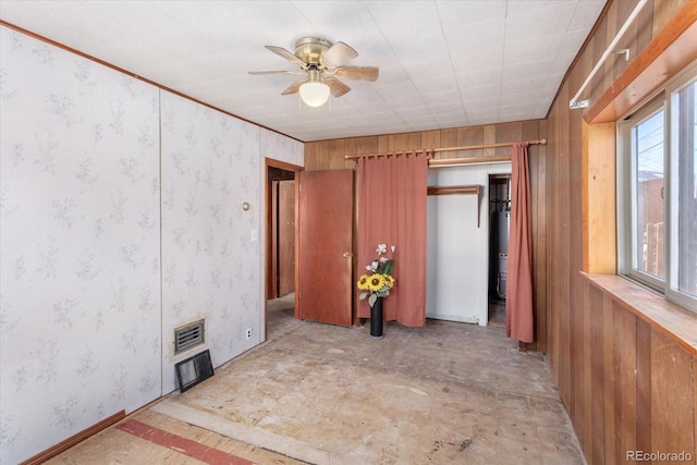 unfurnished bedroom with ceiling fan, wood walls, and water heater