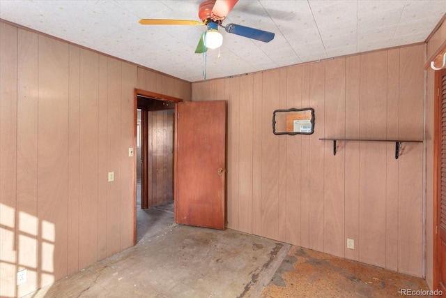 spare room featuring wooden walls and ceiling fan