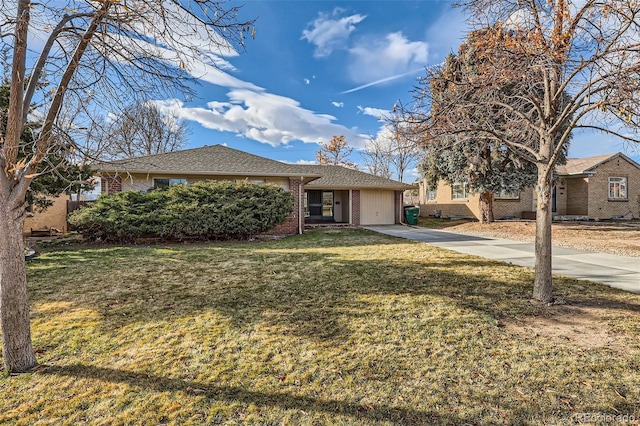 view of front of property featuring a front lawn, concrete driveway, and brick siding